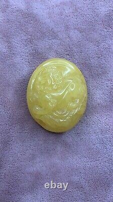 Natural Baltic Amber cabochon with lion carving. Egg yolk
