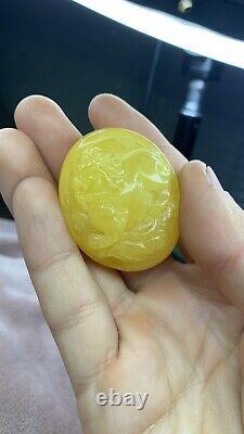 Natural Baltic Amber cabochon with lion carving. Egg yolk